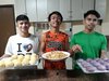 Philippinen: Drei Jungs mit Backwaren fuer Notleidende