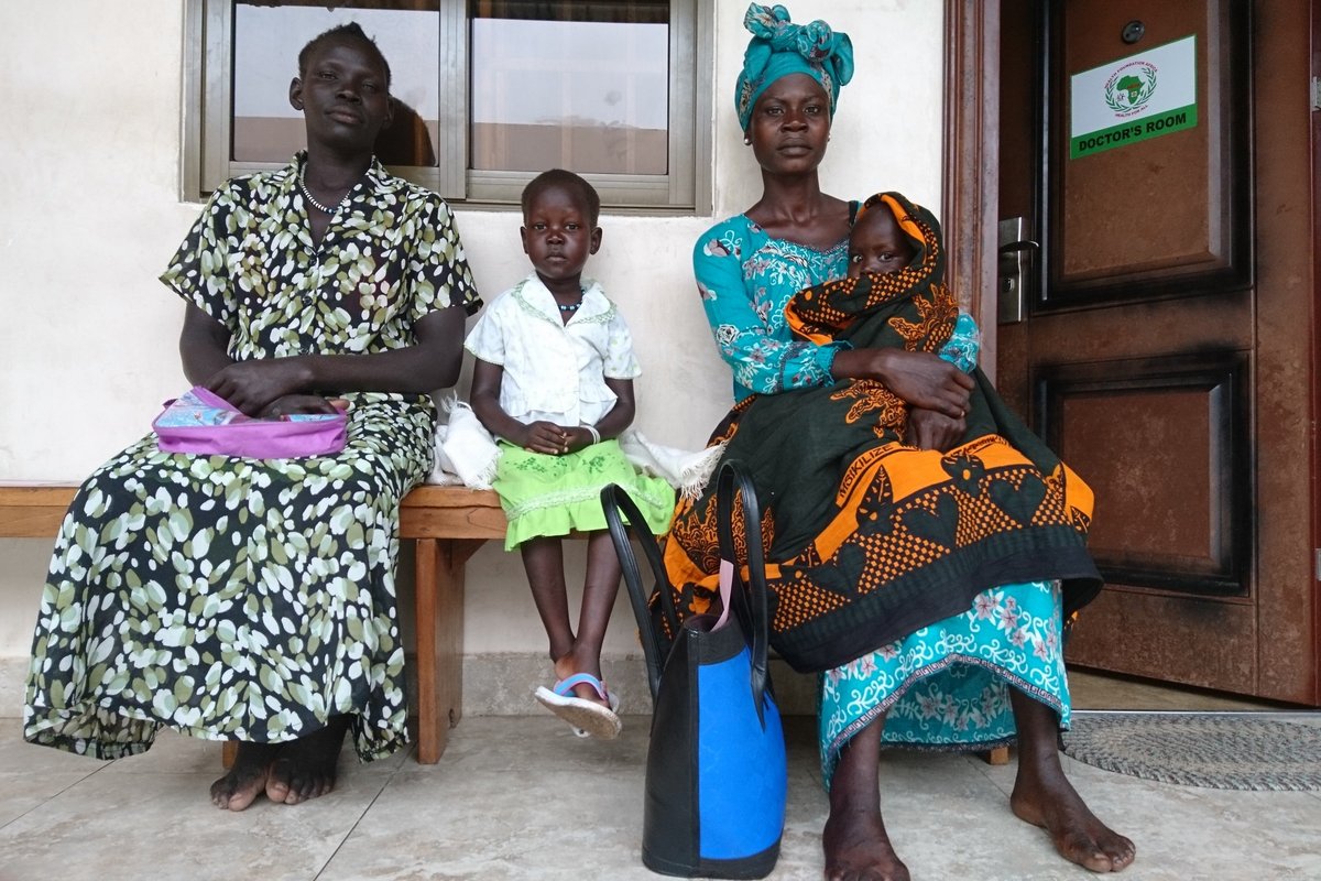 Südsudan: Frauen und Kinder vor einer Don Bosco Krankenstation