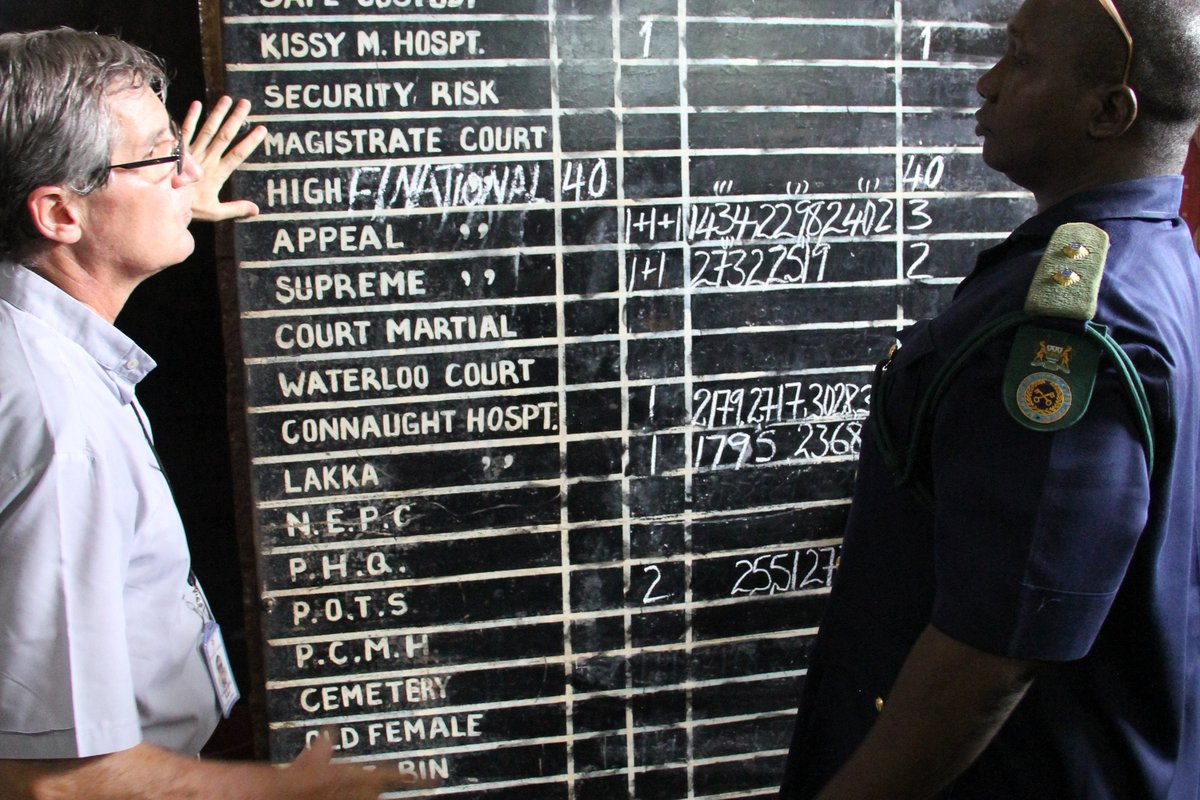 Sierra Leone: P. Jorge mit Gefängnispersonal vor einer Übersichtstafel