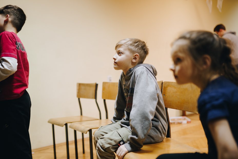 Ukraine: Geflüchtetes Kind sitzt auf einem Tisch