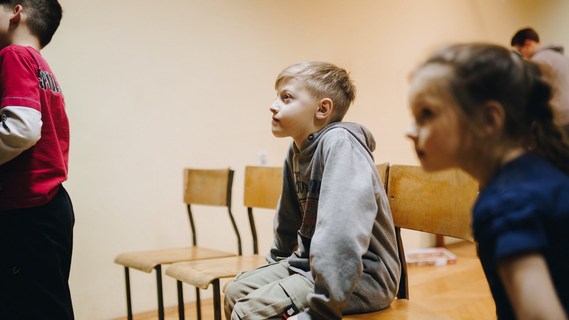 Ukraine: Geflüchtetes Kind sitzt auf einem Tisch