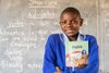 Sambia: Kind mit Schulbuch