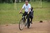 Cover Weltwerker: Pater Crisafulli mit Junge auf Fahrrad