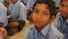 Indien: sitzender Junge blickt in Kamera