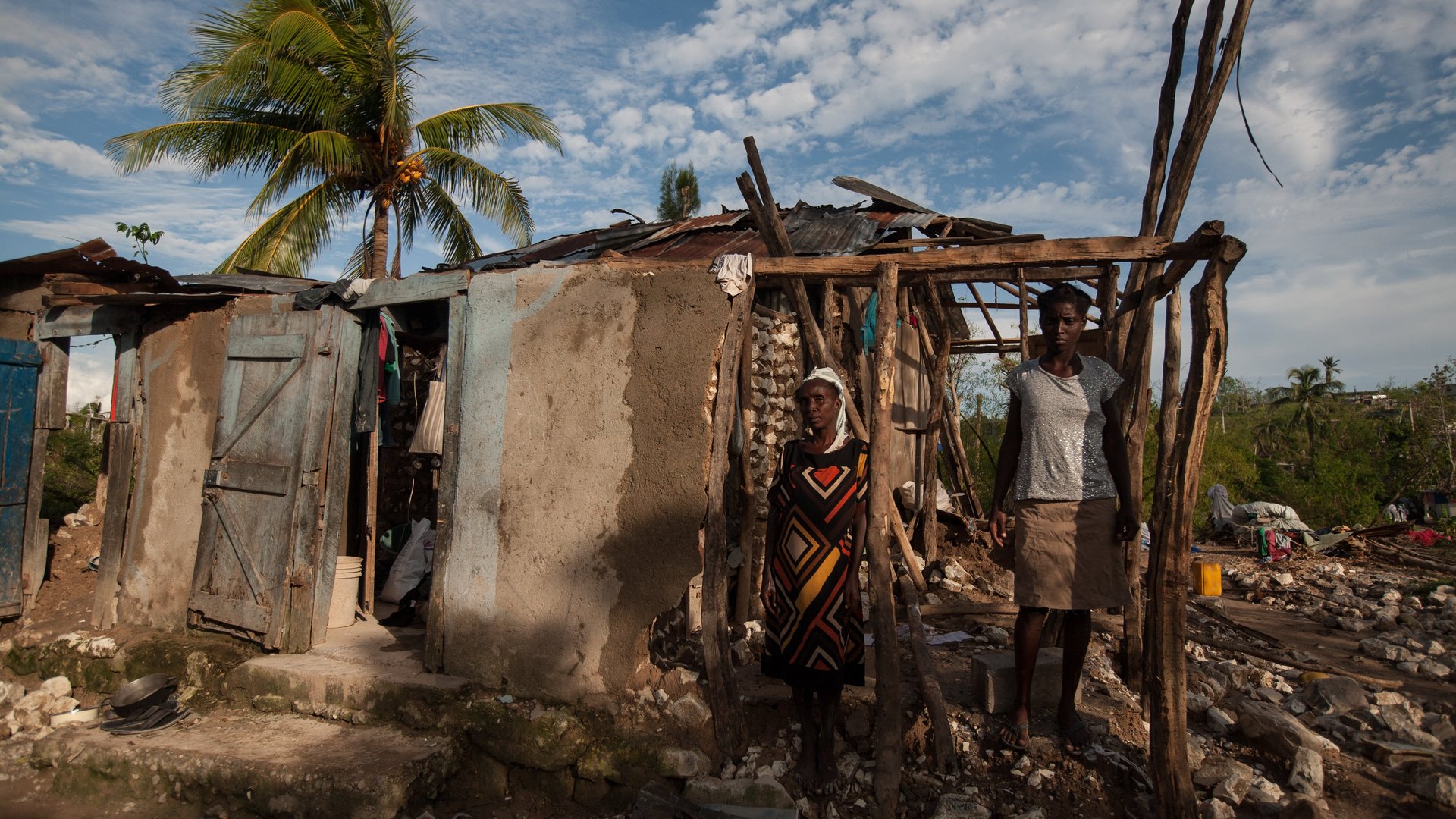 Haiti: Bewohner vor zerstoertem Haus
