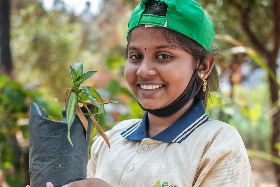Indien: Kind mit Pflanze