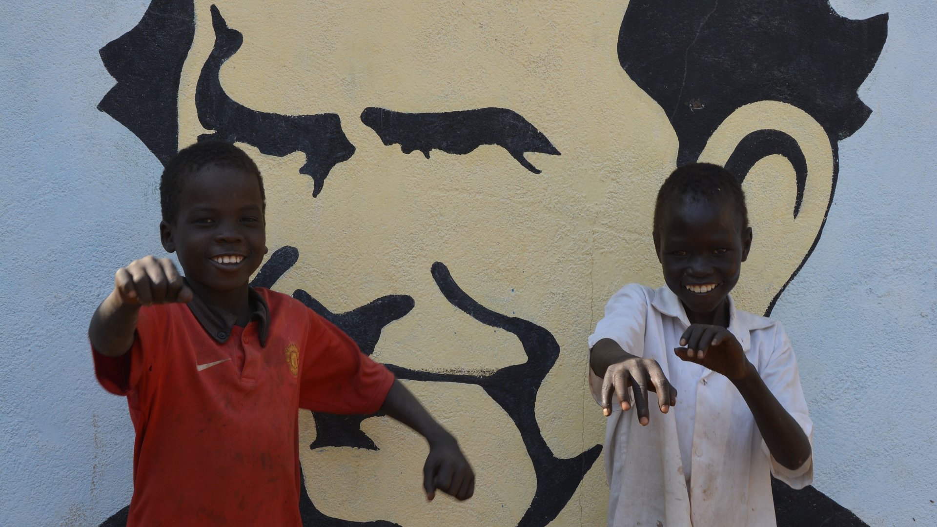 Zwei afrikanische Jungen vor Don Bosco Wandbild